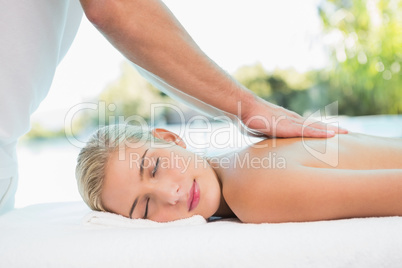 Woman receiving back massage at spa center