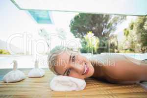 Beautiful woman lying on massage table at spa center