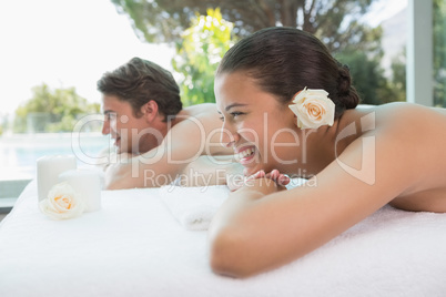 Couple lying on massage table at spa center