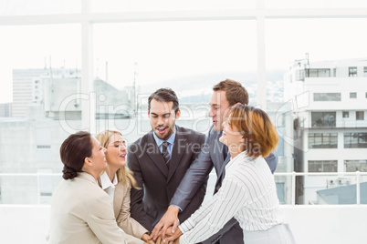 Executives holding hands together in office