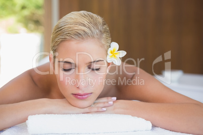 Beautiful woman lying on massage table at spa center