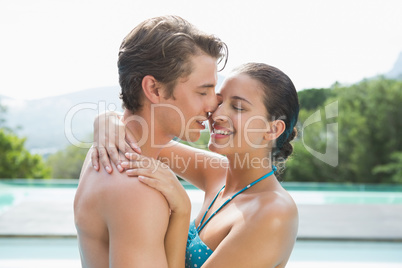 Romantic young couple by swimming pool