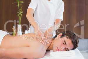 Man receiving back massage at spa center