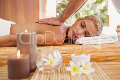 Woman receiving back massage at spa center