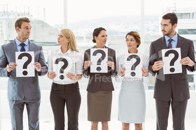 Business people holding question mark signs