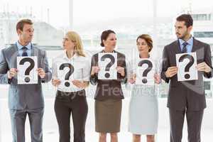 Business people holding question mark signs
