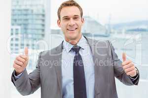 Smart businessman gesturing thumbs up in office