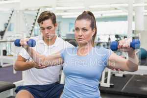 Personal trainer working with client on exercise ball