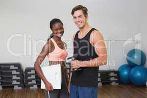 Personal trainer working with client holding scales