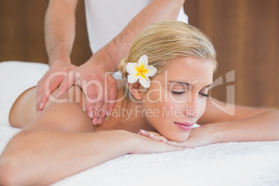 Woman receiving shoulder massage at spa center