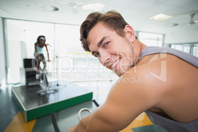 Handsome man smiling at camera in spin class