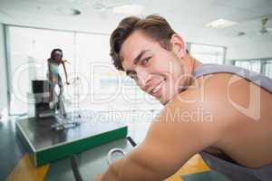 Handsome man smiling at camera in spin class