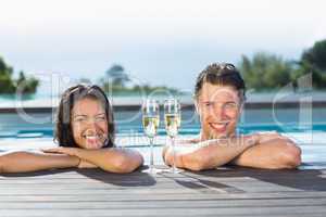 Couple with champagne flutes in swimming pool