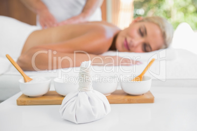 Woman receiving back massage at spa center