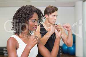 Fit couple standing with fists raised