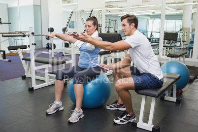 Personal trainer working with client on exercise ball