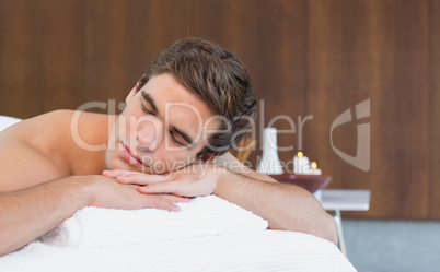 Man lying on massage table at spa center