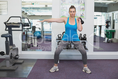 Fit brunette working out with kettlebell