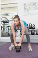 Fit brunette working out with kettlebell