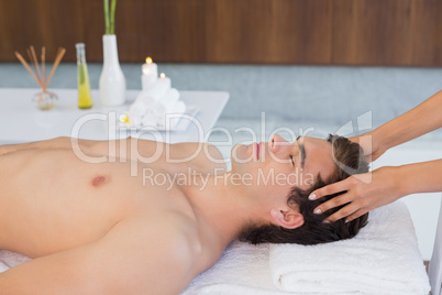 Young man receiving head massage at spa center