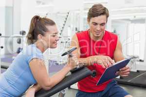 Personal trainer working with client holding dumbbell