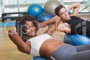Couple doing sit ups on exercise balls