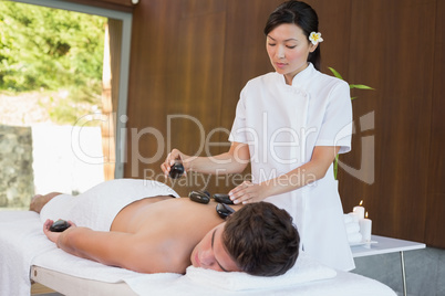 Man receiving stone massage at spa center