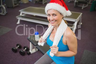 Festive brunette smiling at camera in fitness studio