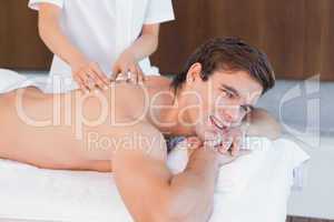 Man receiving back massage at spa center