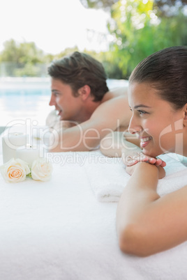 Couple lying on massage table at spa center