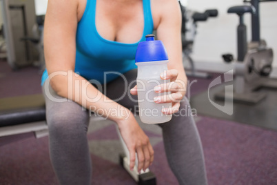 Fit brunette holding sports bottle