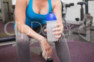 Fit brunette holding sports bottle