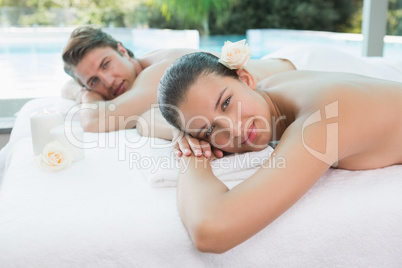 Couple lying on massage table at spa center