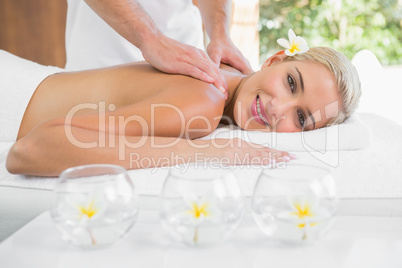 Woman receiving shoulder massage at spa center