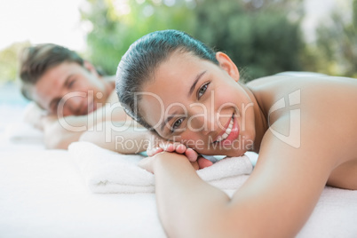 Couple lying on massage table at spa center