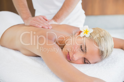 Woman receiving back massage at spa center