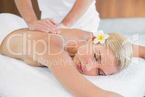 Woman receiving back massage at spa center