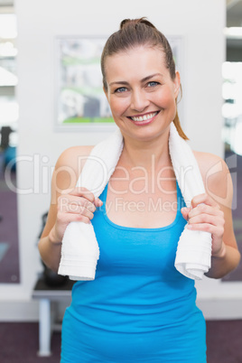 Fit brunette smiling at camera in fitness studio