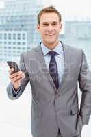 Businessman holding mobile phone in office