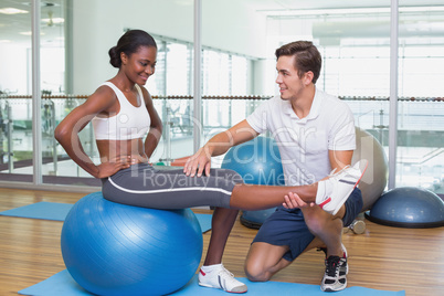 Personal trainer working with client on exercise ball