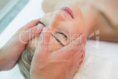 Attractive woman receiving head massage at spa center