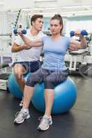 Personal trainer working with client on exercise ball