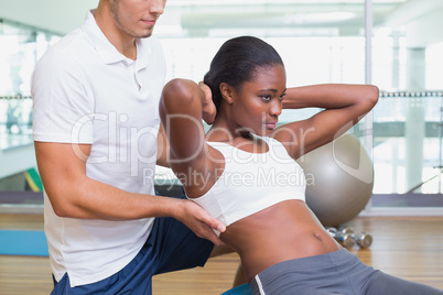 Personal trainer working with client on exercise ball