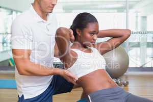 Personal trainer working with client on exercise ball