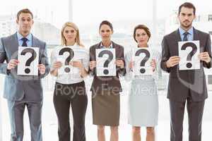 Business people holding question mark signs