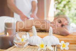 Woman receiving back massage at spa center