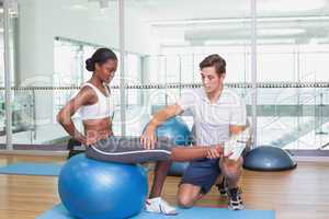 Personal trainer working with client on exercise ball