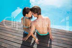 Romantic young couple by swimming pool