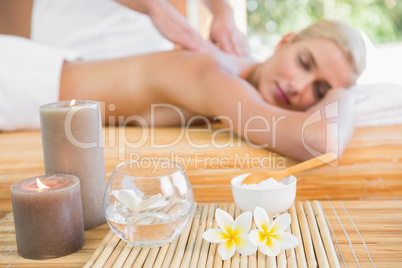 Woman receiving back massage at spa center