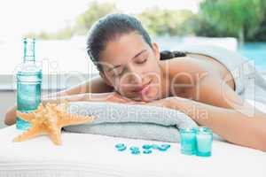 Woman lying on massage table at spa center